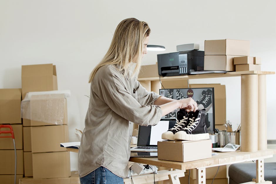 A woman packs sneakers in a box at her e-commerce workspace, surrounded by packing materials